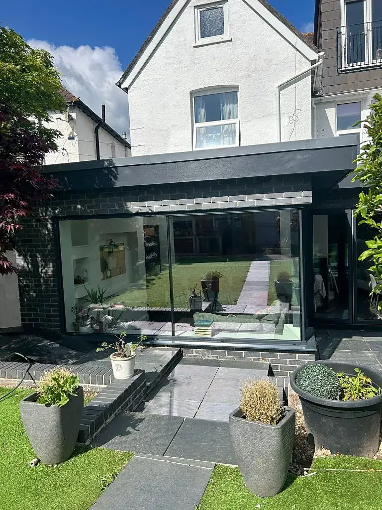 Dark aluminium rear extension with full-height glazing looking onto a planted garden