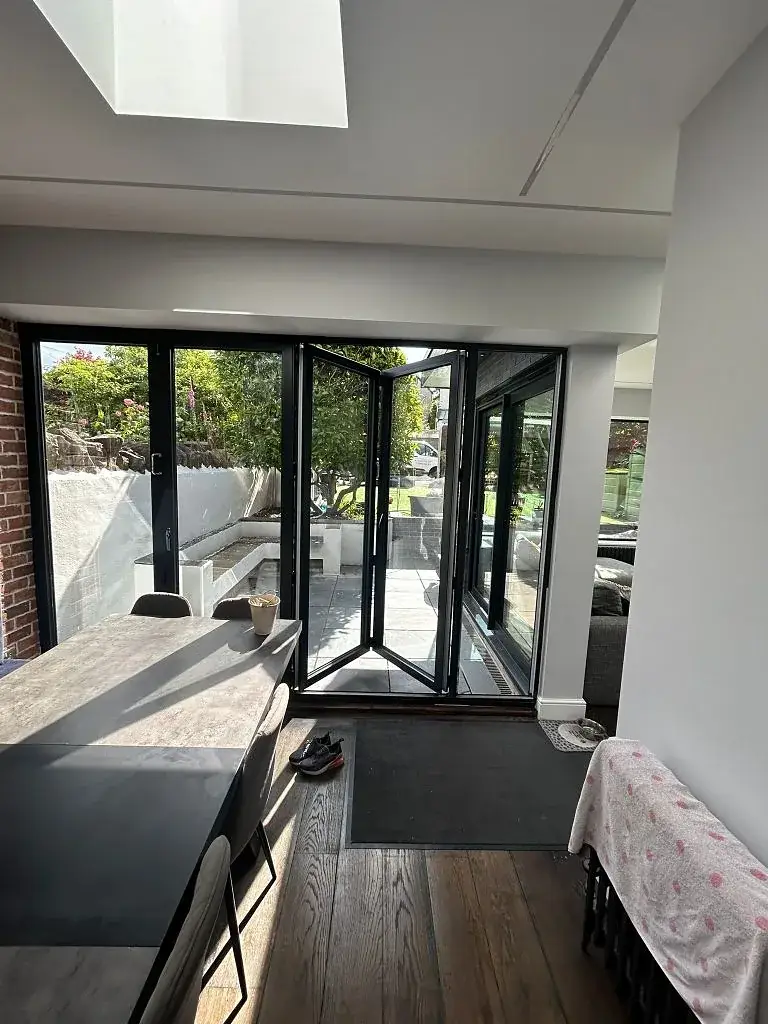 Extension interior looking out through bi-fold doors onto a paved garden