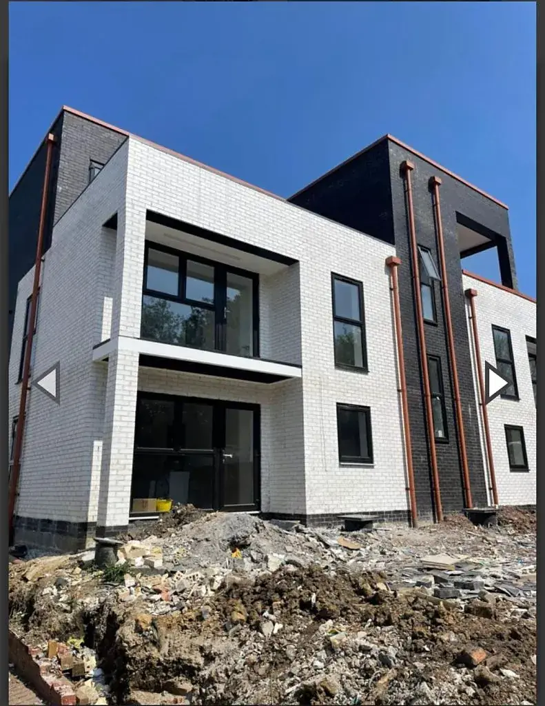 Contemporary new build in white brick with dark-framed windows