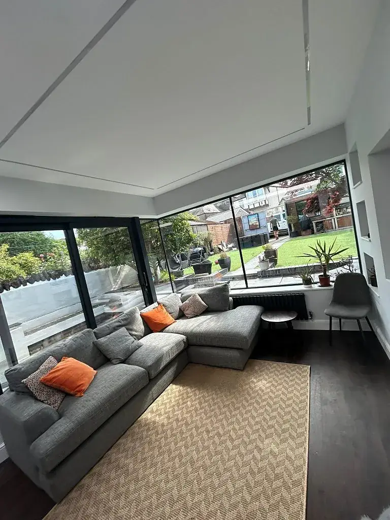 Open-plan lounge with corner glazing looking out onto the garden
