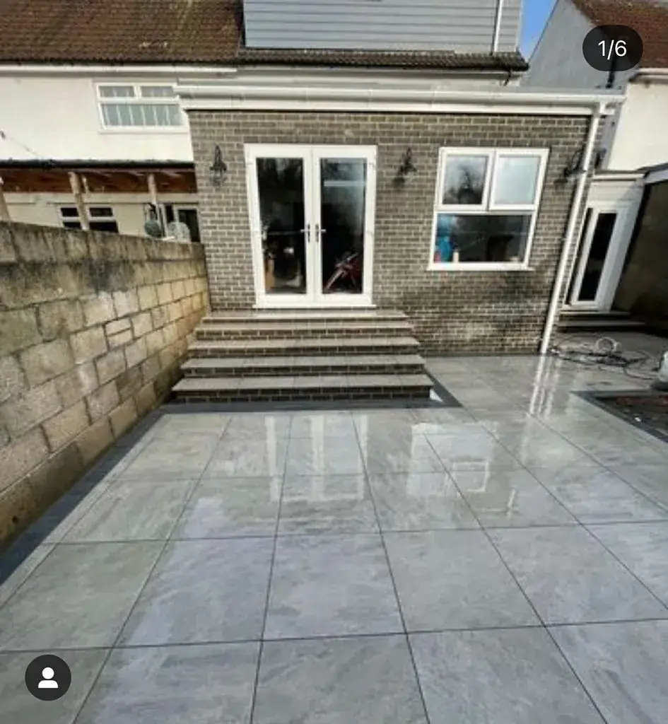 Porcelain patio with wide steps rising to the French doors of a house