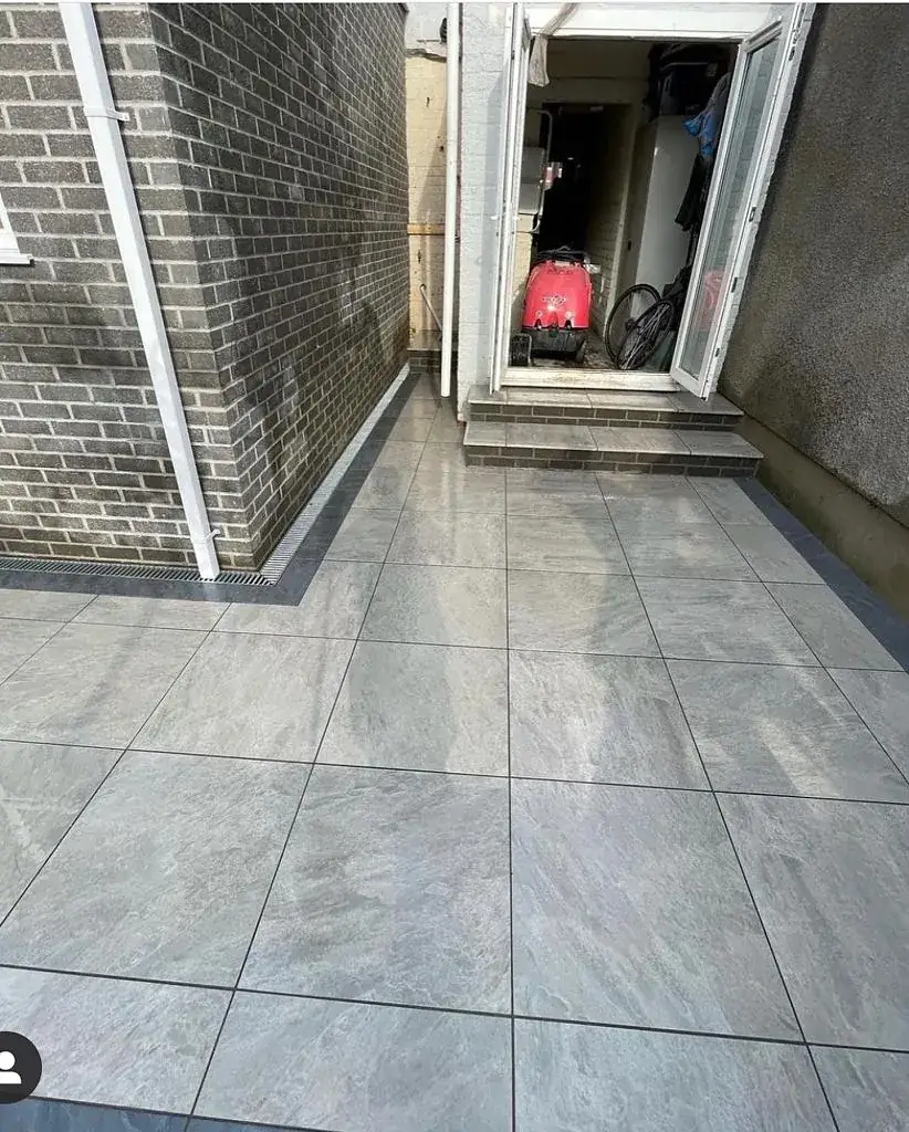 Large-format porcelain paving laid against a rendered wall