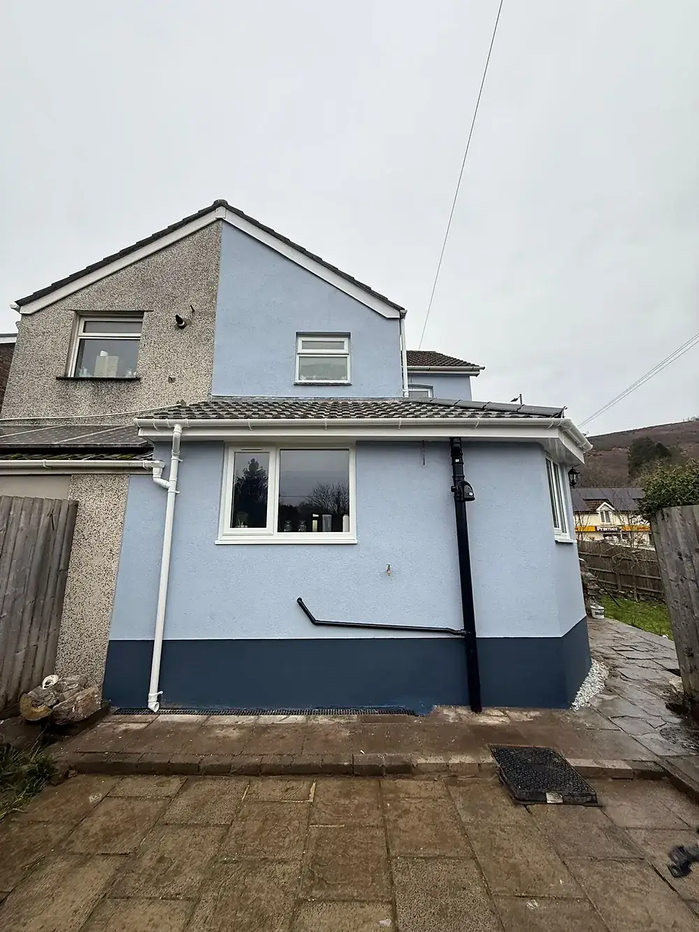 Rendered rear elevation of a house with hills behind it