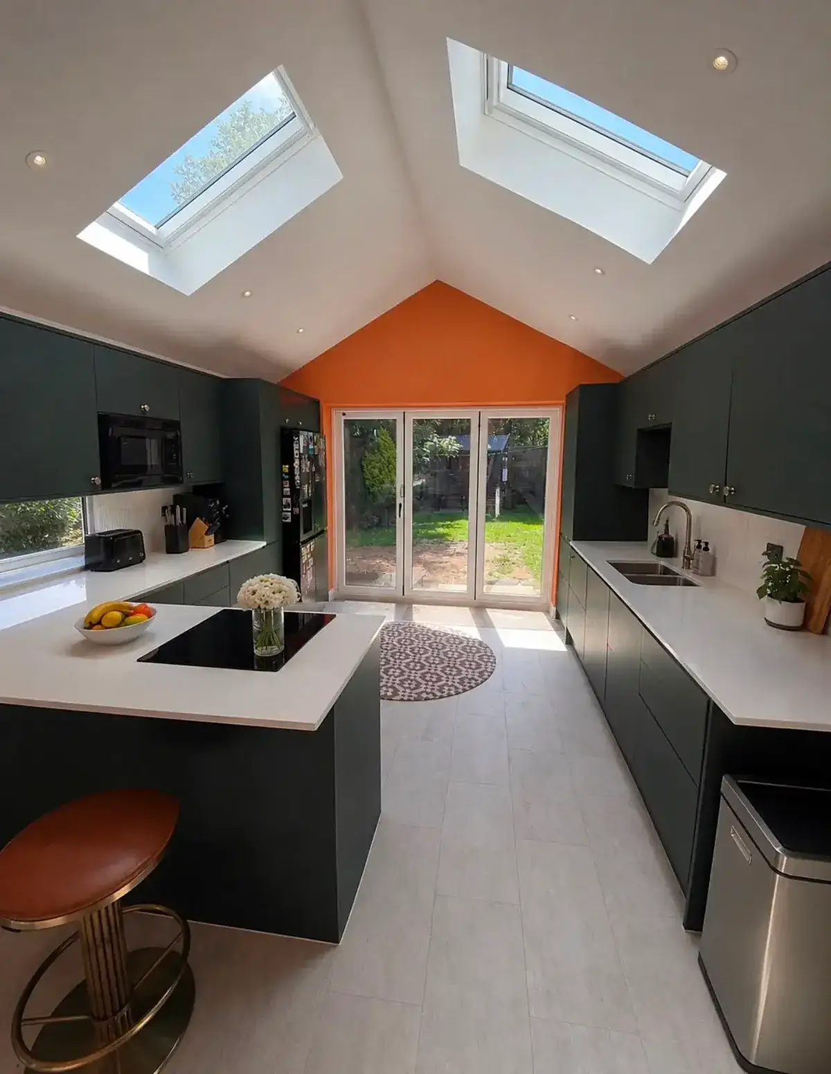 Kitchen extension with a vaulted ceiling, rooflights and an orange gable wall